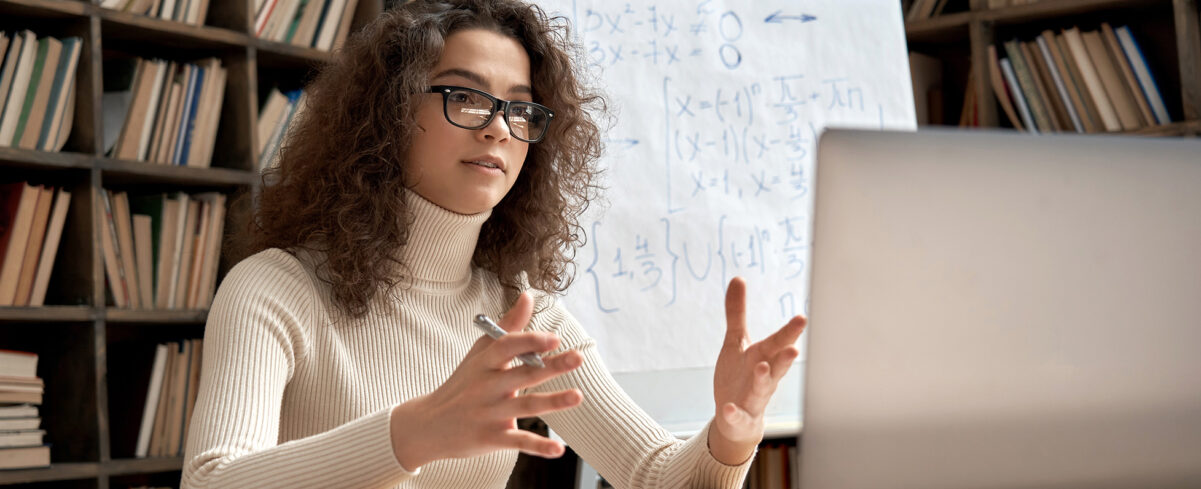 Woman gesturing in front of her computer